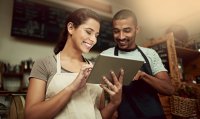 Latino small business owners viewing tablet together