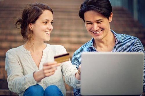 Young couple using a credit card to shop online