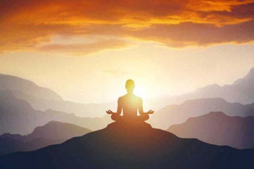 Silhouette of a man meditating on a mountain