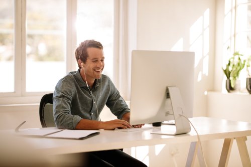 Man smiling while working at his computer
