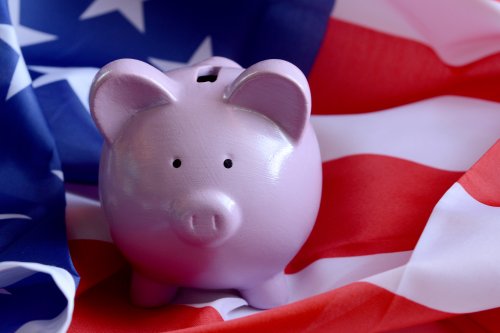 Piggy bank sitting on American flag