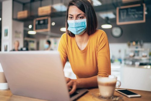 Small business owner wearing a medical mask and working on computer