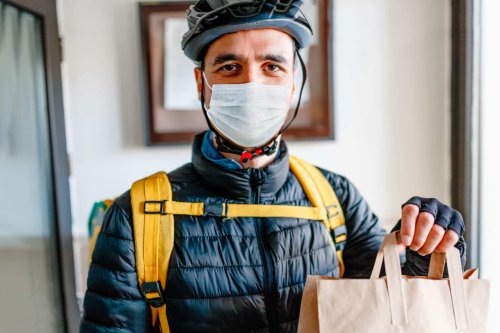 Employee of delivery business wearing medical mask