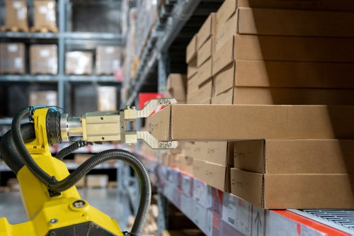 Robotic arm carrying inventory in a warehouse