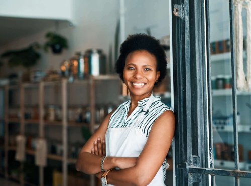 Confident black business woman standing outside her business