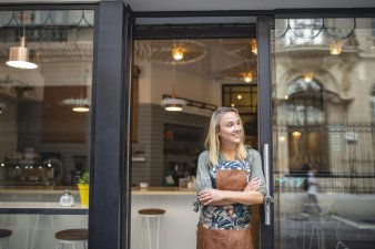 Young female business owner standing outsider her new cafe