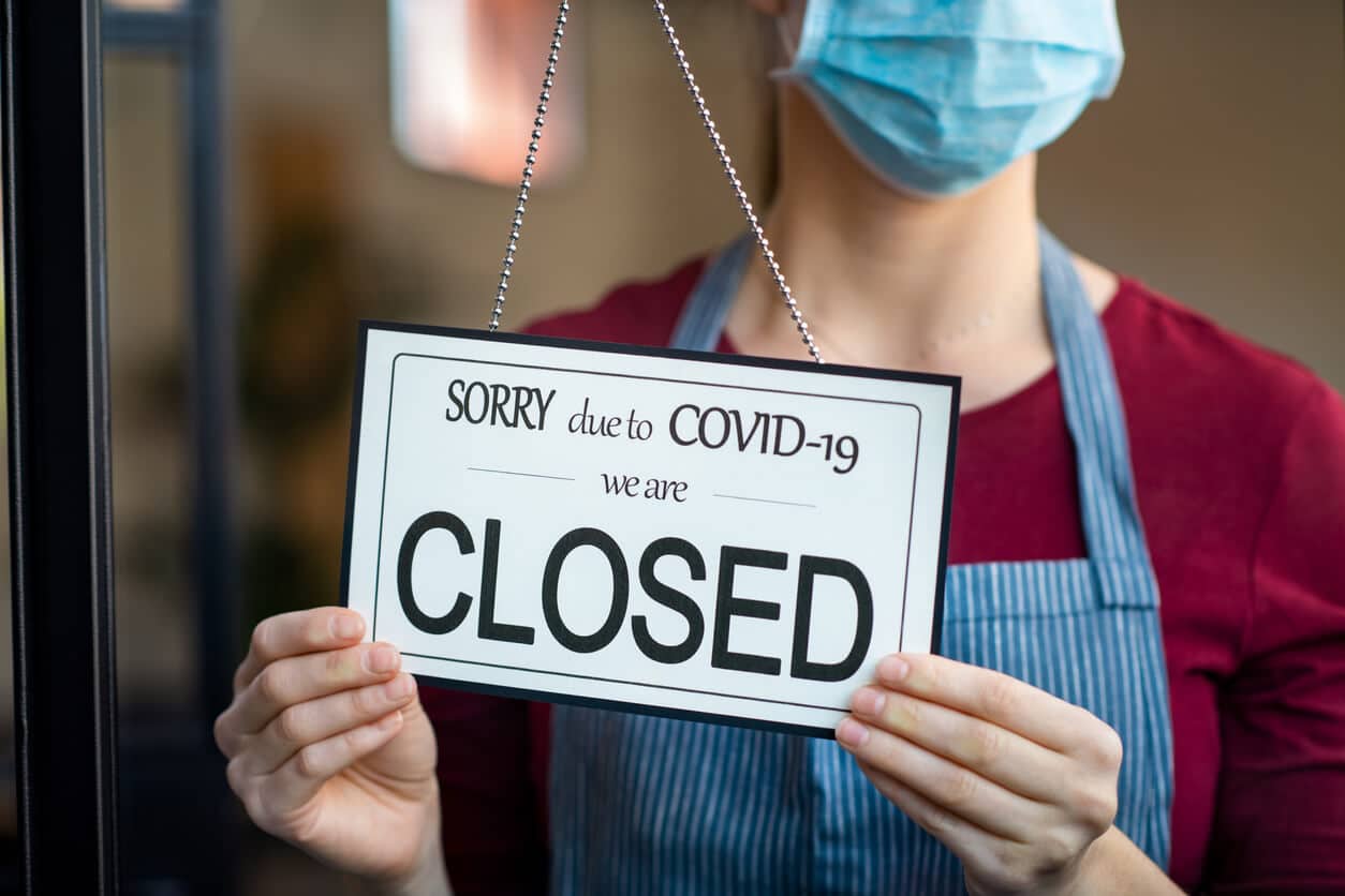 Business owner hanging "Closed" sign