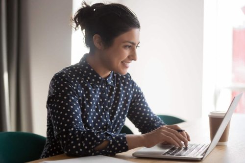Female employee smiling at laptop