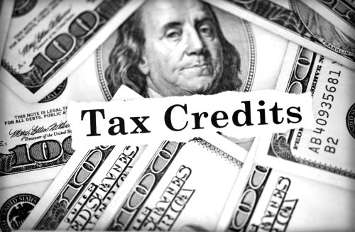 Tax Credits in front of $100 bills