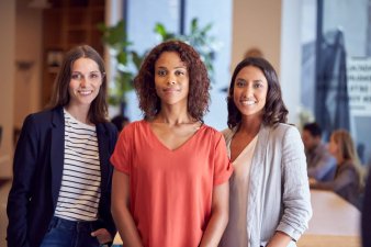 Three Businesswomen Stand Together in Office