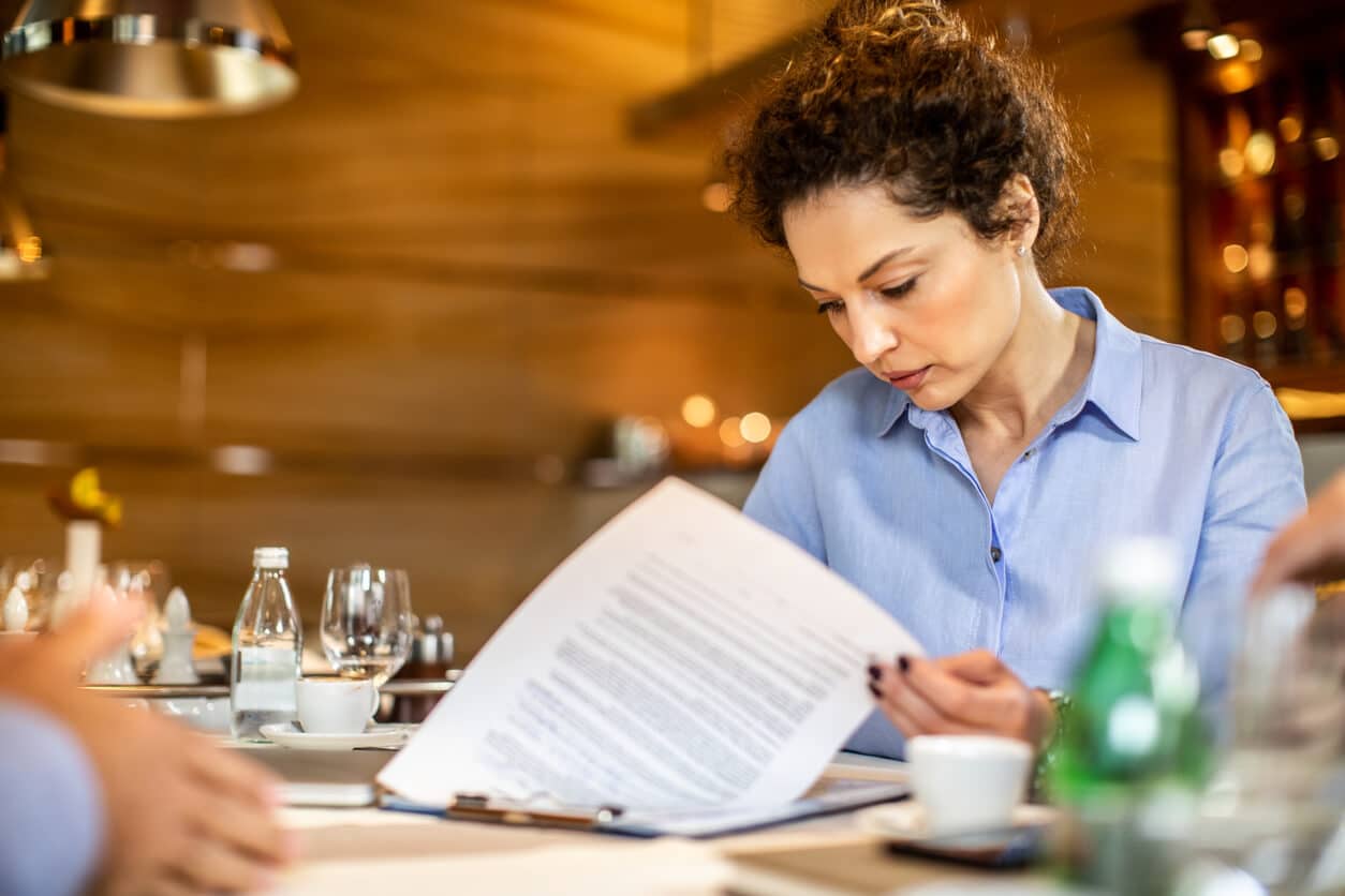 Woman signing documents in restaurant