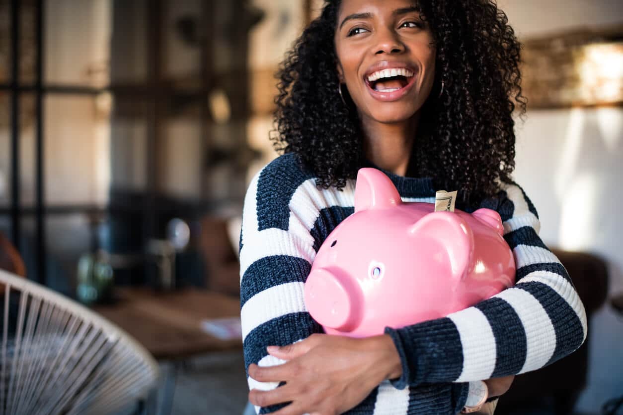 Black woman hugging a piggy bank