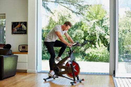 Man exercising on bike in his home