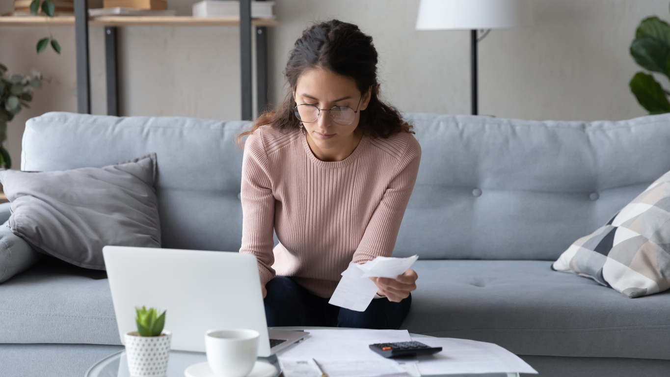 Woman managing finances from her couch