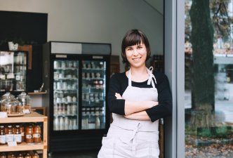 Small Business Owner standing in entryway smiling