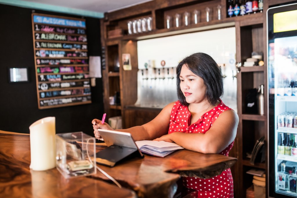 Small business owner doing bookkeeping in a bar