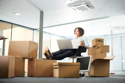 A business owner sits amongst her moving in boxes