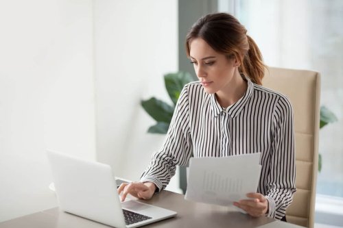 Serious focused businesswoman typing on laptop and applying for loan