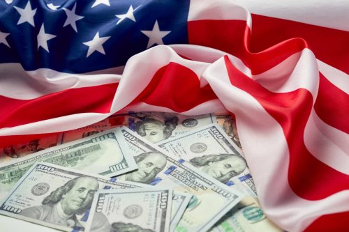 American Flag laying on dollar bills