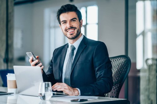 Young caucasian accountant smiling at his desk