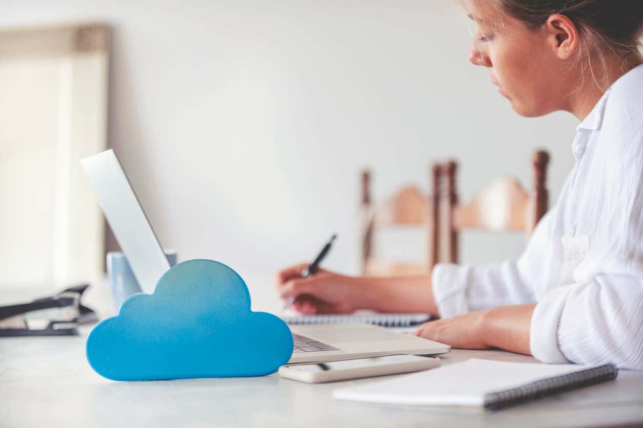 Woman using computer with cloud icon