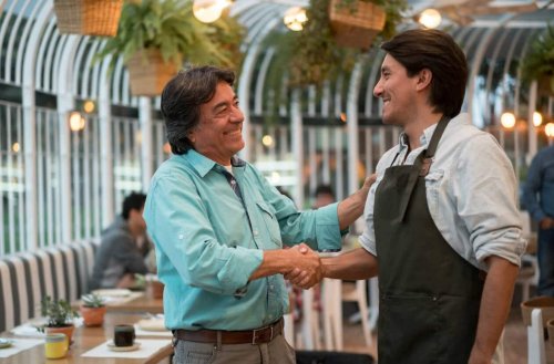 Two men shake hands in a restaurant they own