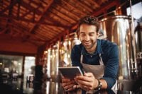 Owner of brewery works on tablet
