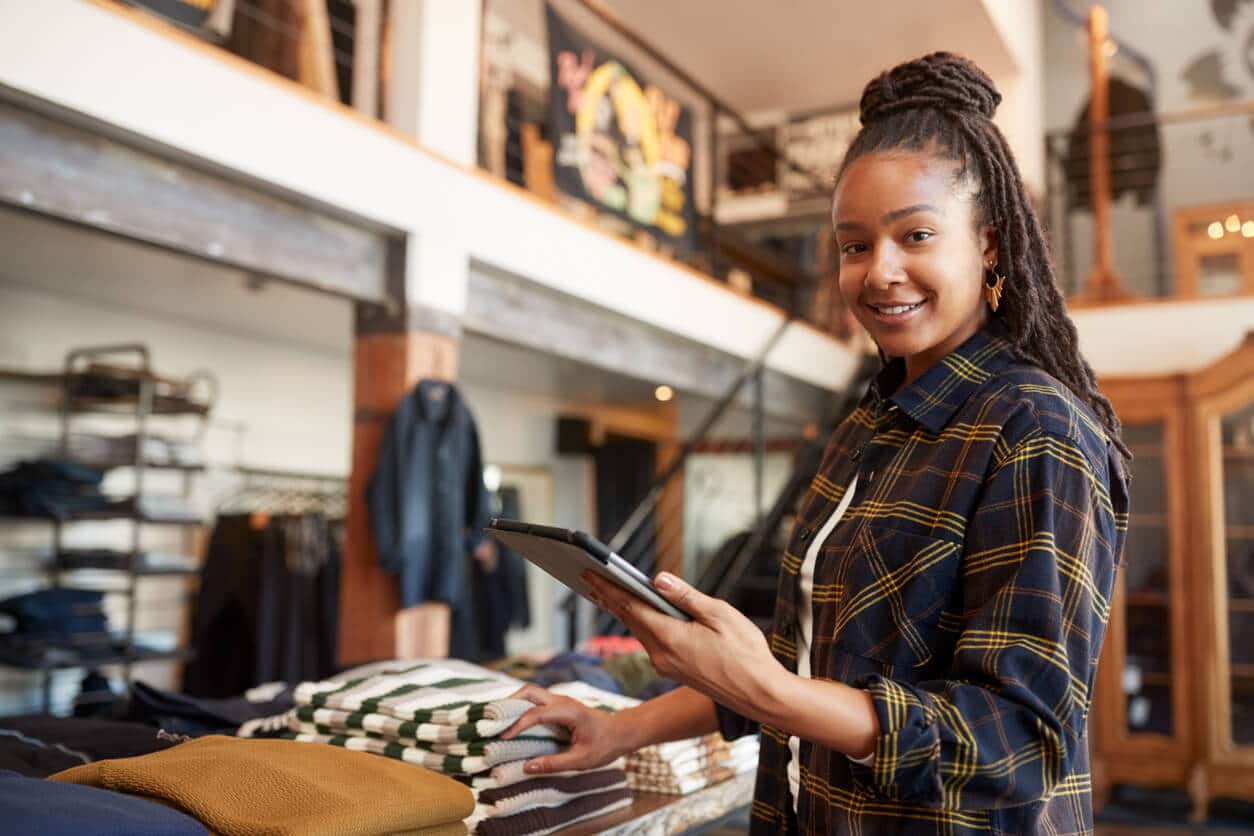 Clothing store owner sorts clothing