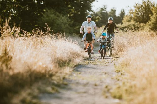 Family with two children riding on a bike path